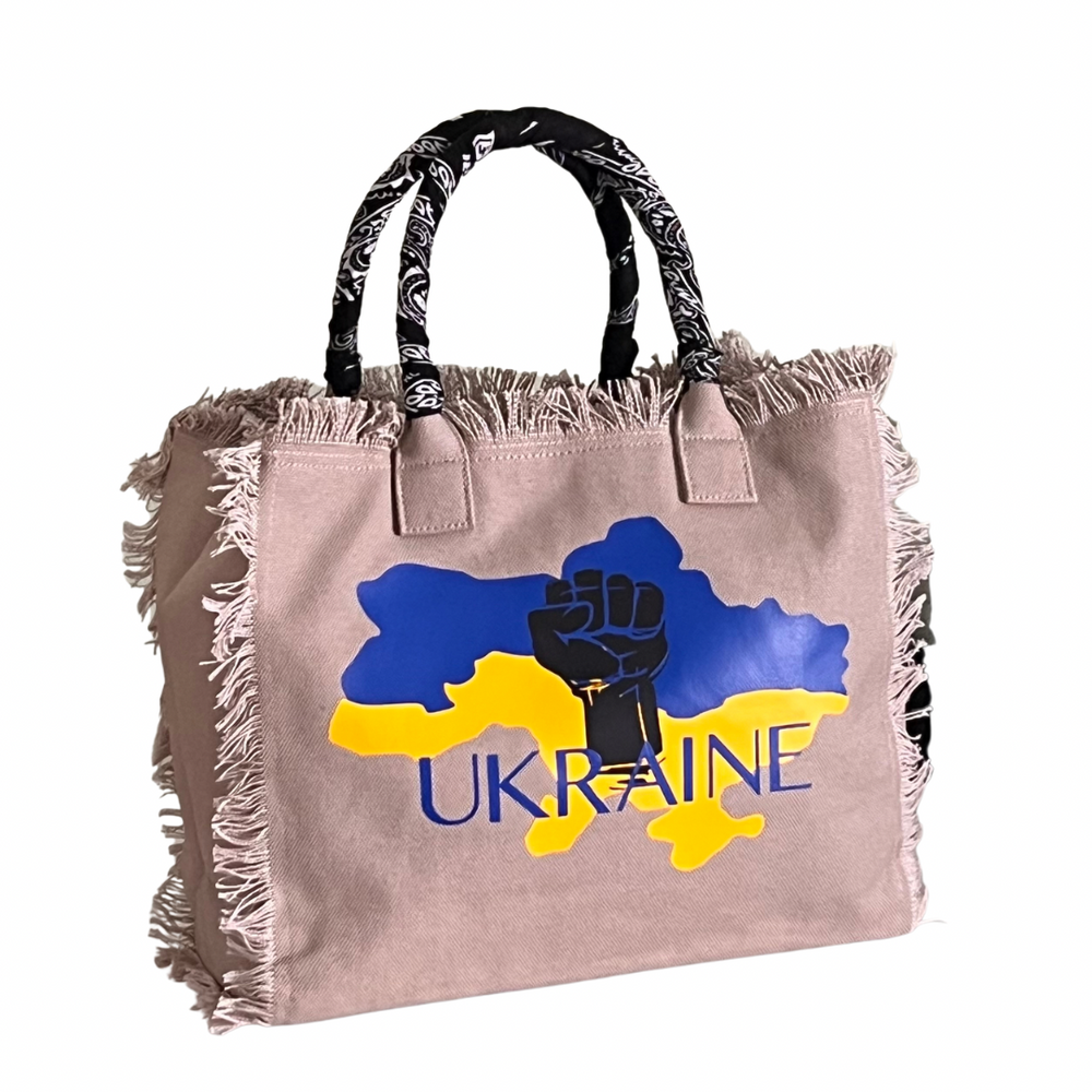 FUNDRAISER - Ukraine Shoulder Tote - Beige
This expressive tote was designed as part of the Sandi_J Strength & Unity Tote Collection. The unique design signifies standing in solidarity with our Ukrainian sisters and brothers. 50% of proceeds will be donated to SIFH Global (501c3) for the purchase and delivery of diesel generators to Ukraine Fully lined canvas tote with soft-support bottom and bandana covered handles. Inside bag has 1 convenient inside zippered pockets and 2 insert pockets. Bag handles are a