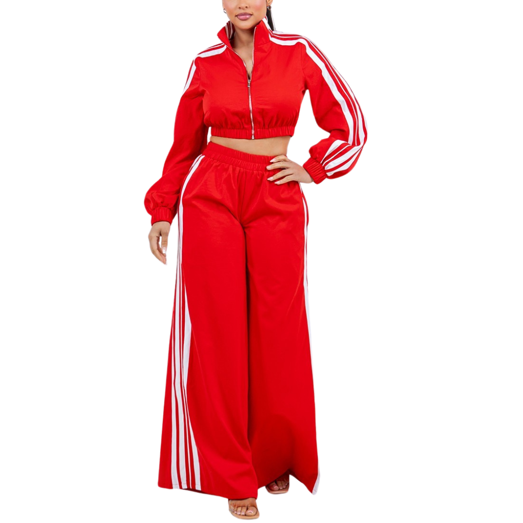 Red tracksuit with white stripes worn by a model on a white background