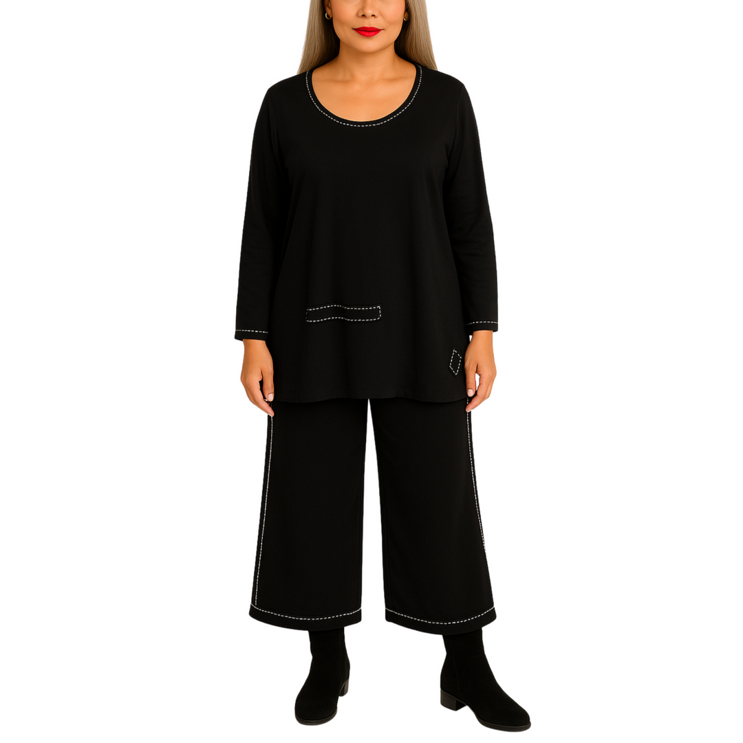 Woman wearing a black outfit with white stitching on a white background