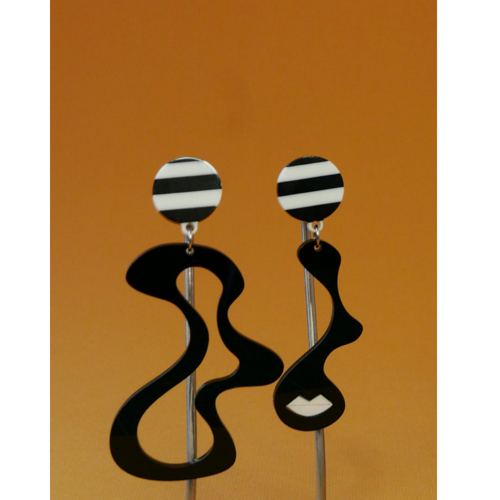 Black and white striped earrings on a brown background