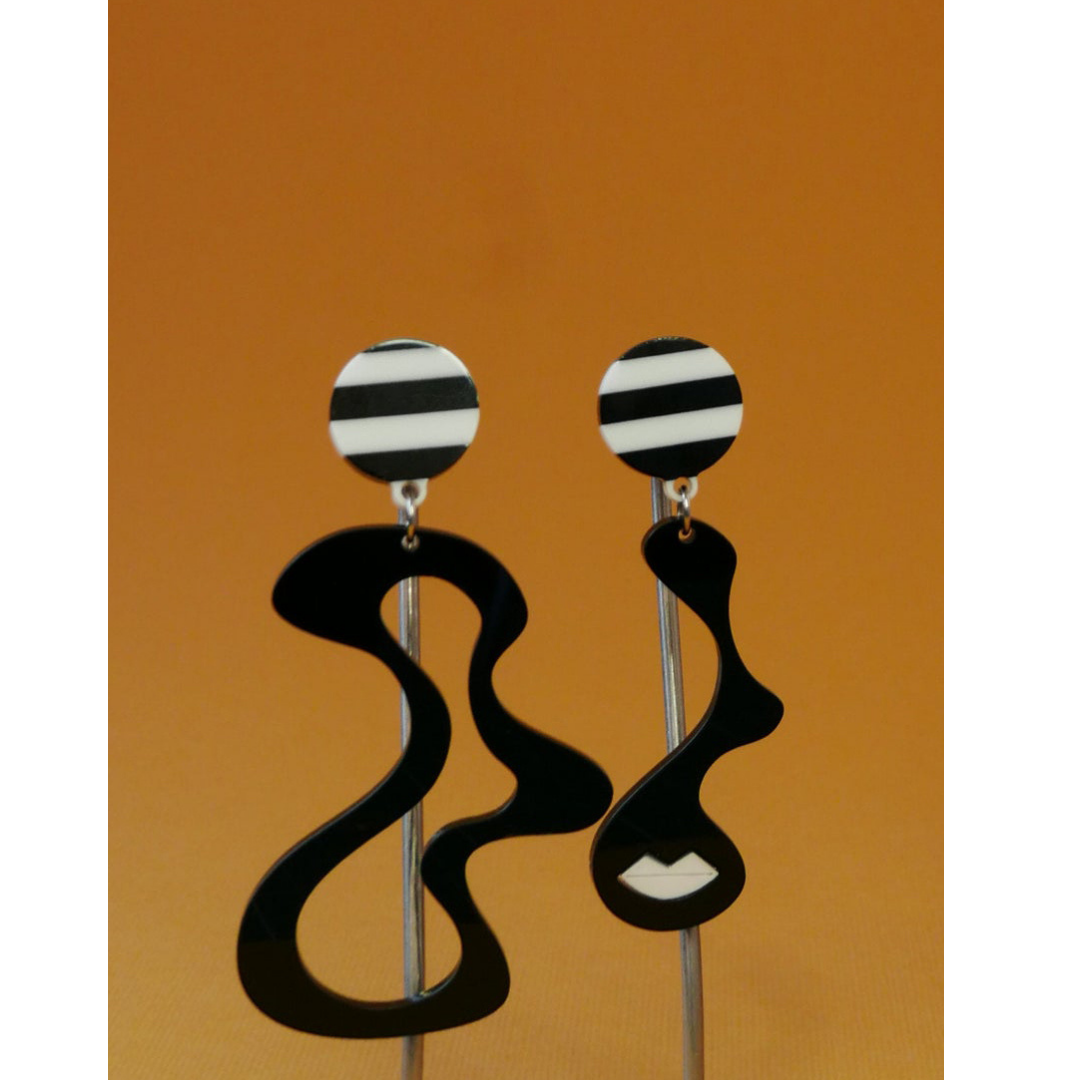 Black and white striped earrings on a brown background