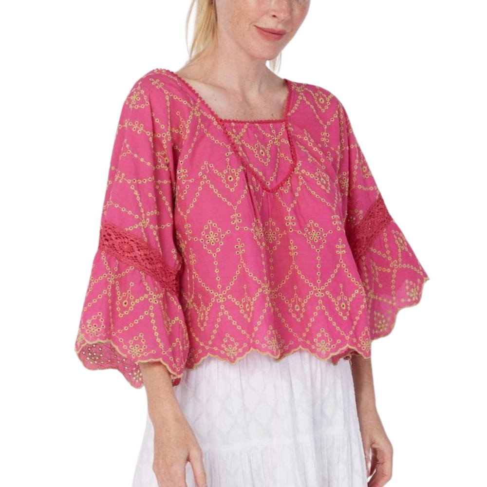 Woman wearing a pink embroidered blouse with a white background