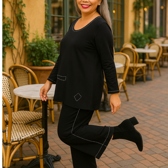 Woman in black outfit posing outdoors with chairs and tables in the background