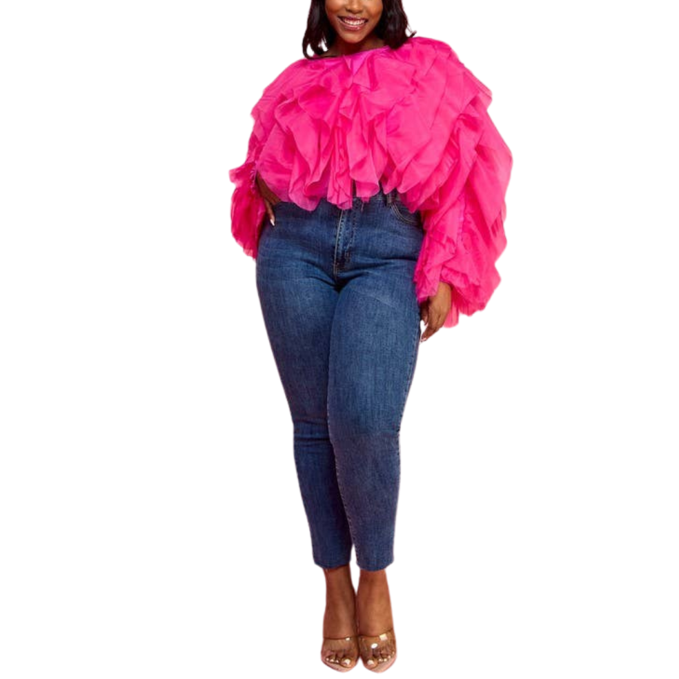 A female model wearing a fuchsia ruffle tulle crop top with long sleeves, paired with blue jeans.