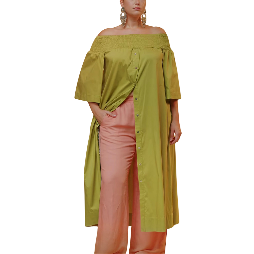 Woman wearing a green off-shoulder top and pink pants on a white background