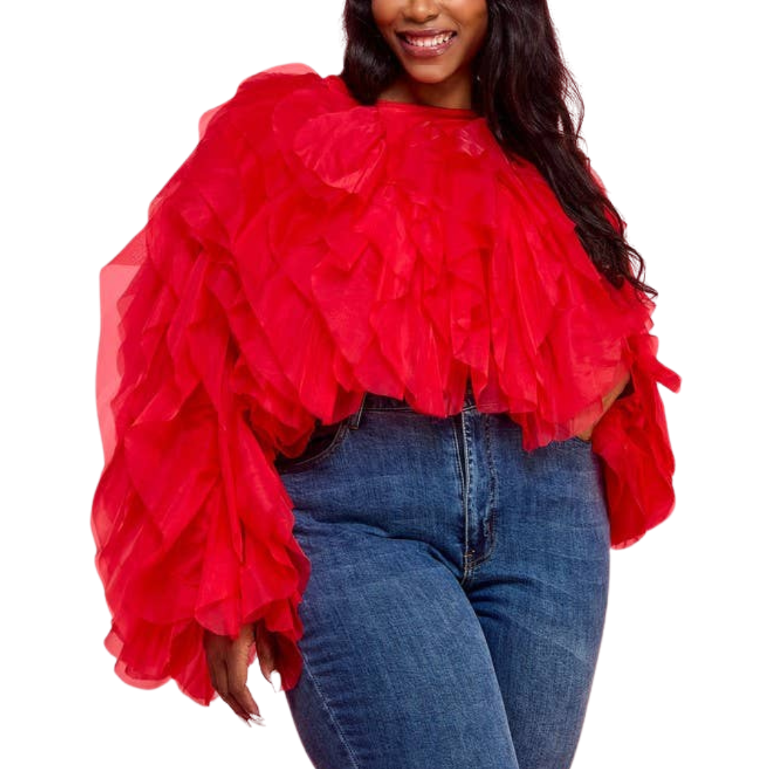 A woman wearing a red ruffle tulle crop top with long sleeves, paired with blue jeans.