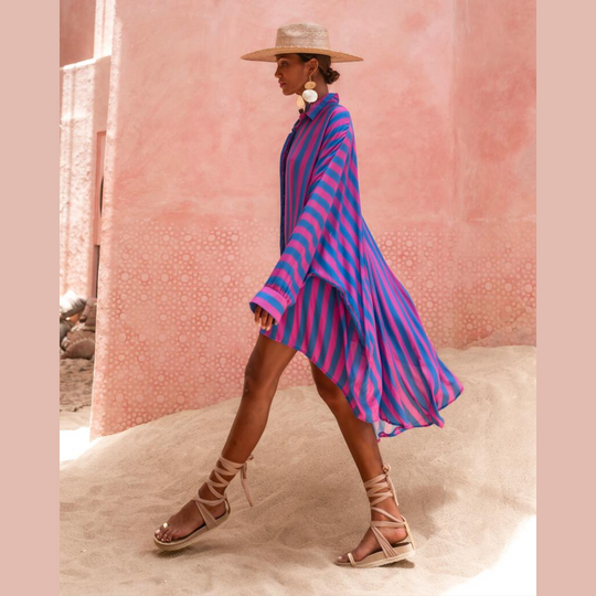 Model wearing oversized striped shirt in fuchsia and indigo with long hem and button front – Erika Peña