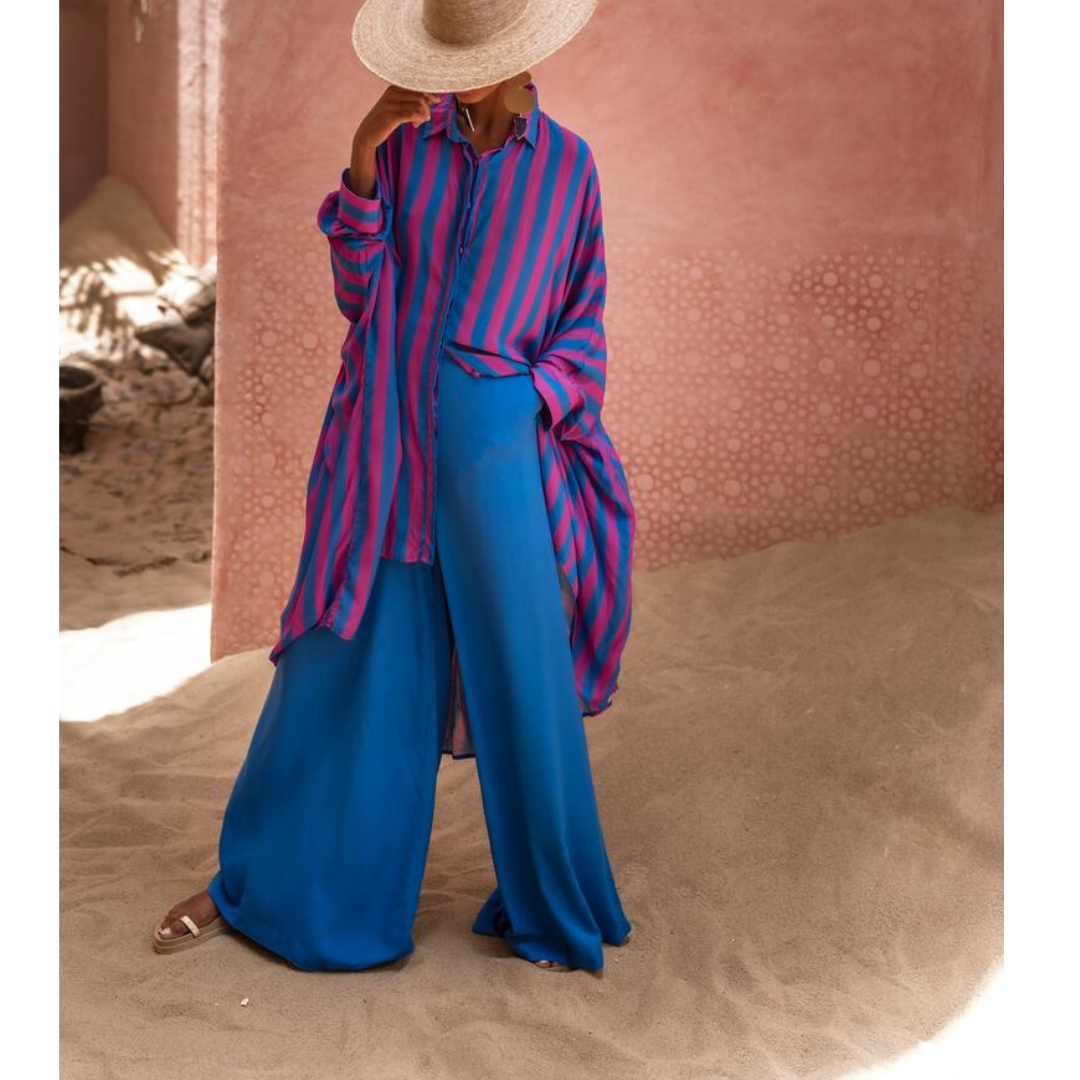 Model wearing oversized striped shirt in fuchsia and indigo with long hem and button front – Erika Peña