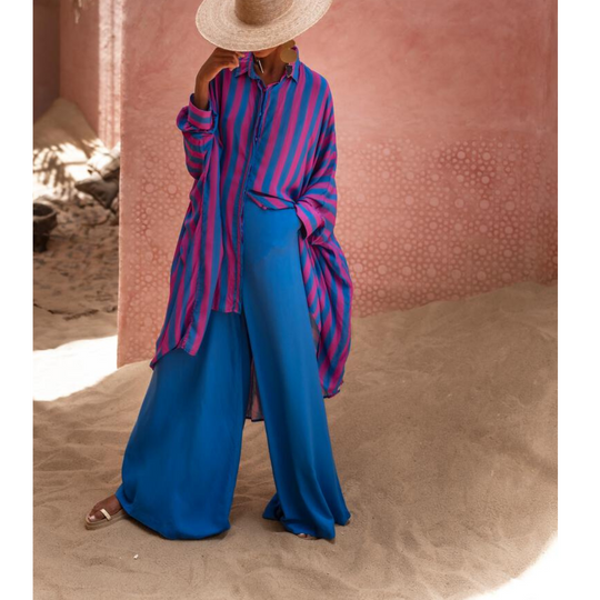 Model wearing oversized striped shirt in fuchsia and indigo with long hem and button front – Erika Peña