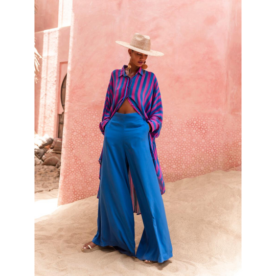 Model wearing oversized striped shirt in fuchsia and indigo with long hem and button front – Erika Peña