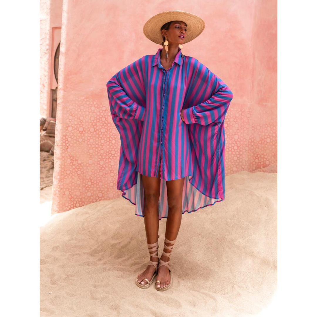 Model wearing oversized striped shirt in fuchsia and indigo with long hem and button front – Erika Peña