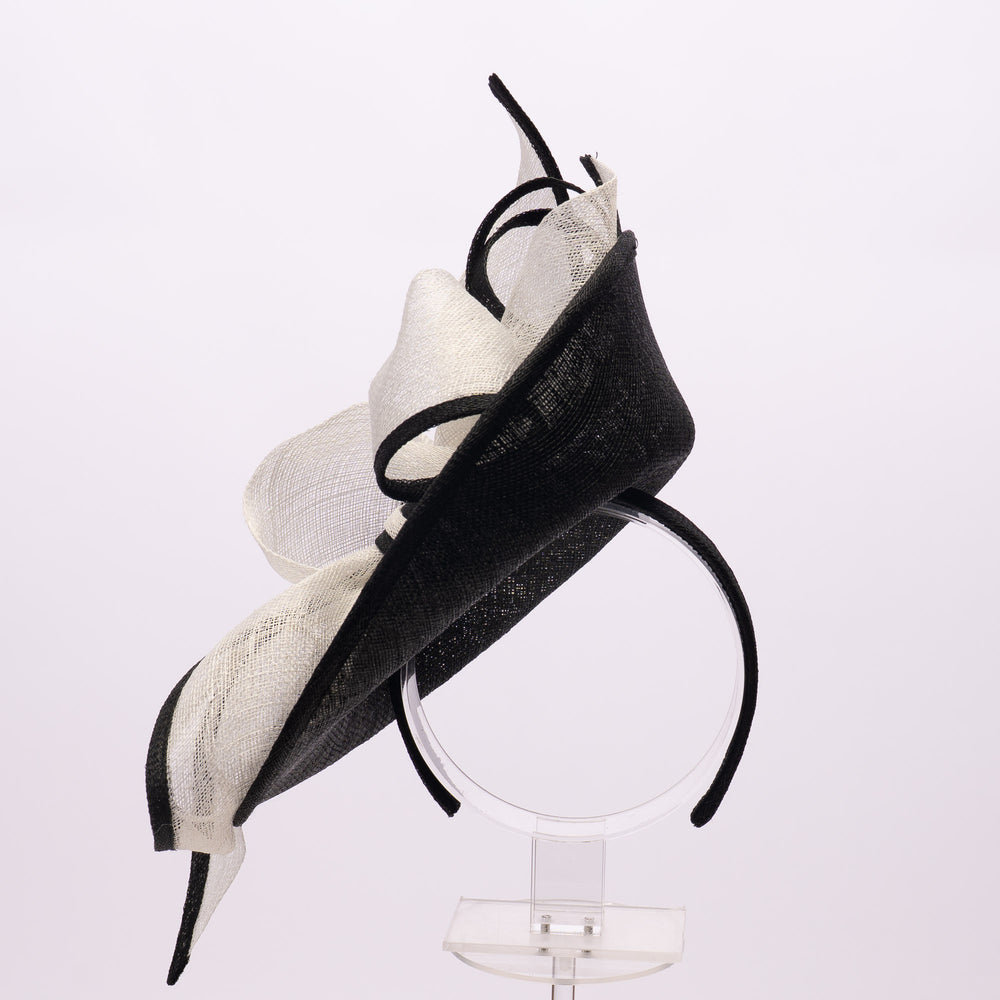 Black and white decorative headpiece on a stand against a light gray background