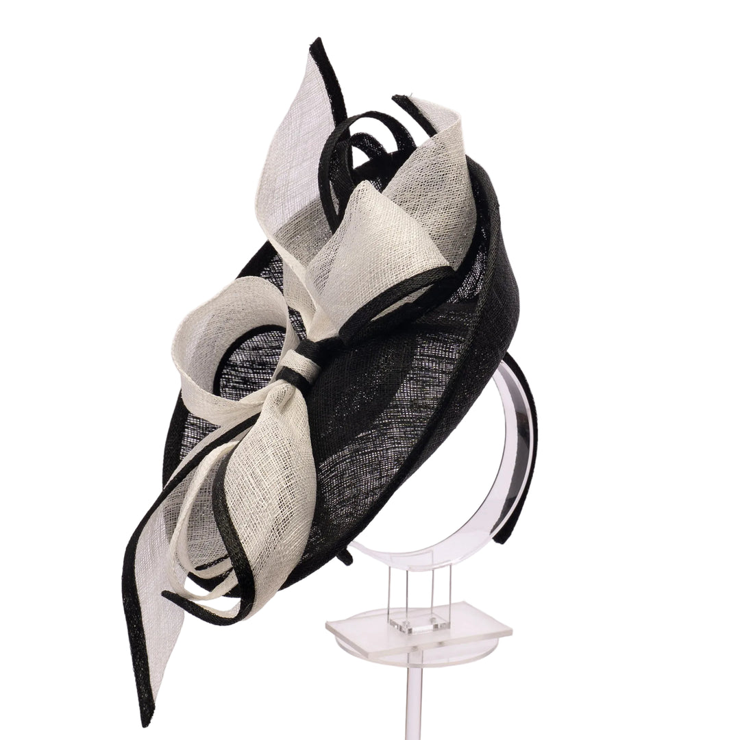 Black and white decorative headpiece on a stand against a light background