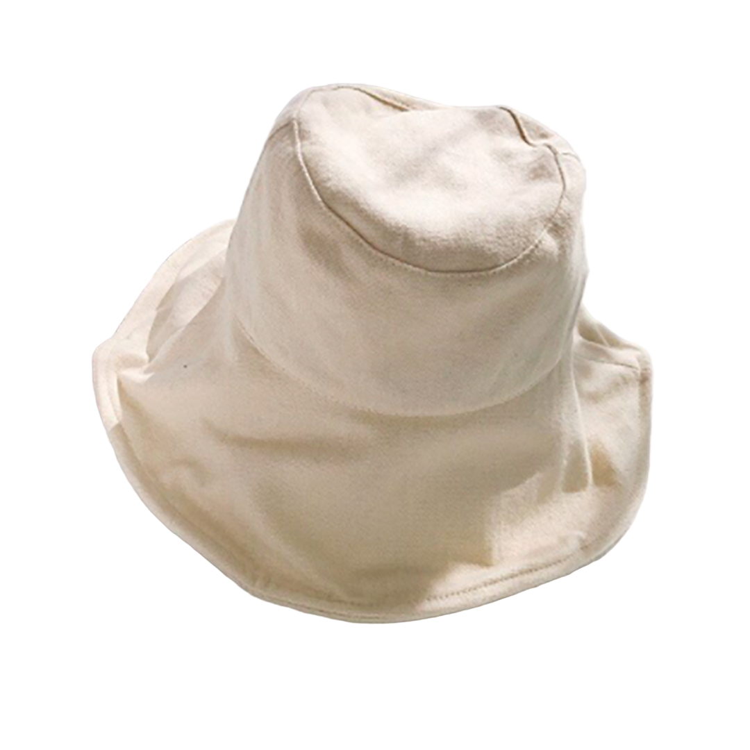 Beige bucket hat on a white surface with a blurred background