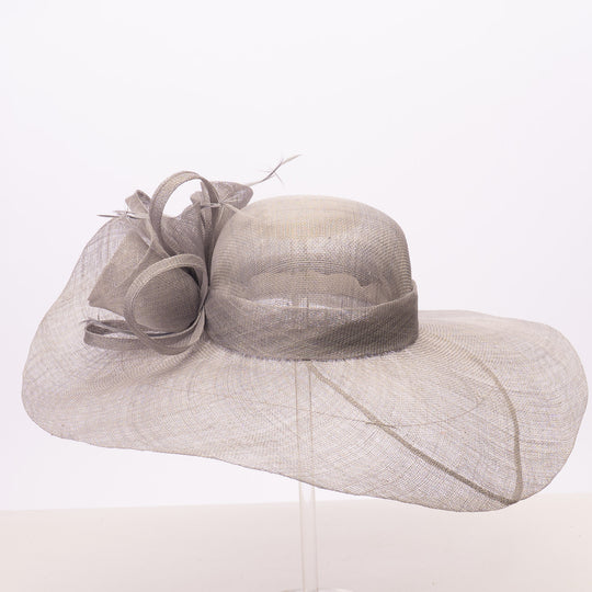 A light gray wide-brimmed fascinator hat with a matching ribbon bow and veil, displayed on a clear stand against a white background.