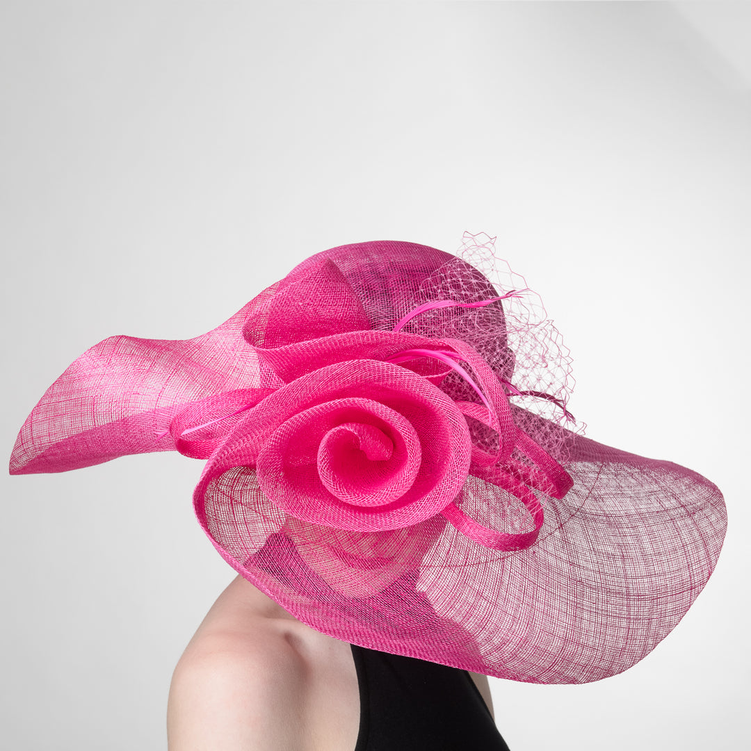 Pink decorative hat with a rose design on a white background