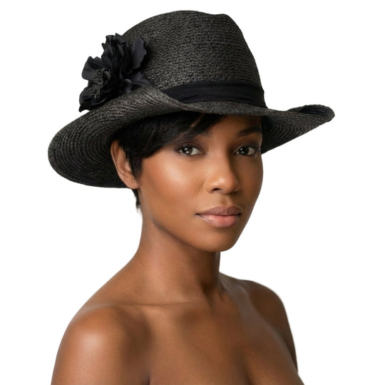 Woman wearing a black straw hat with a flower on a white background