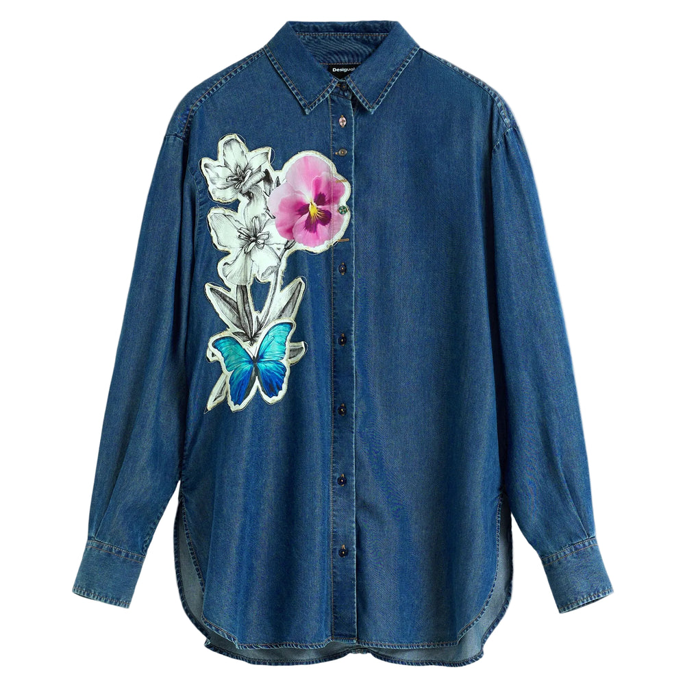 A blue denim button-up shirt with a colorful embroidered floral and butterfly design on the left chest, displayed against a light gray background.