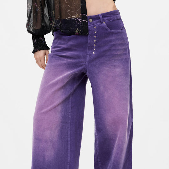 Purple wide-leg corduroy pants with a button fly, shown on a model against a light gray background.