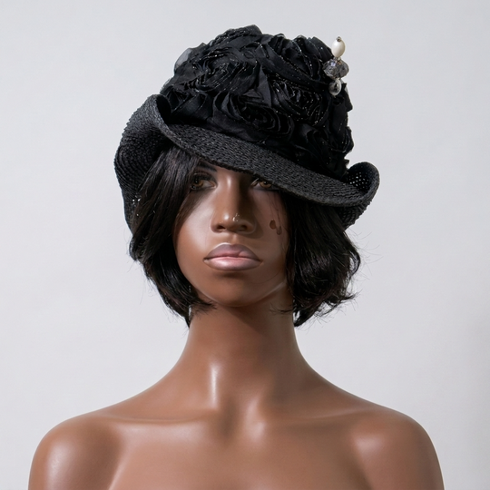 Mannequin head wearing a black floral hat against a plain background