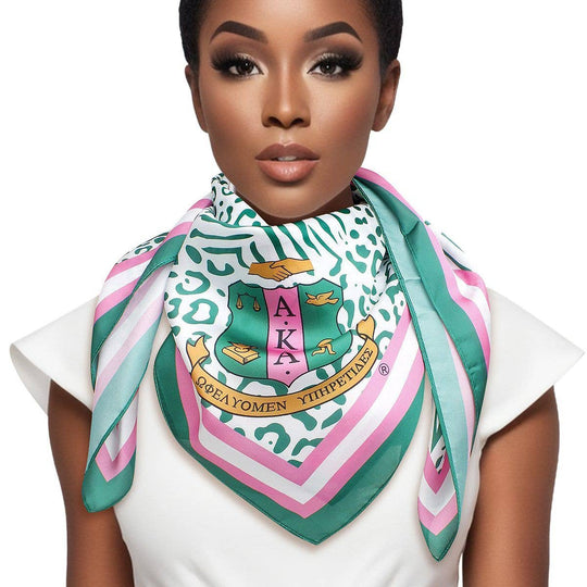AKA Sorority scarf in green, white, and pink animal print with stripe edging, letters, and shield corners.