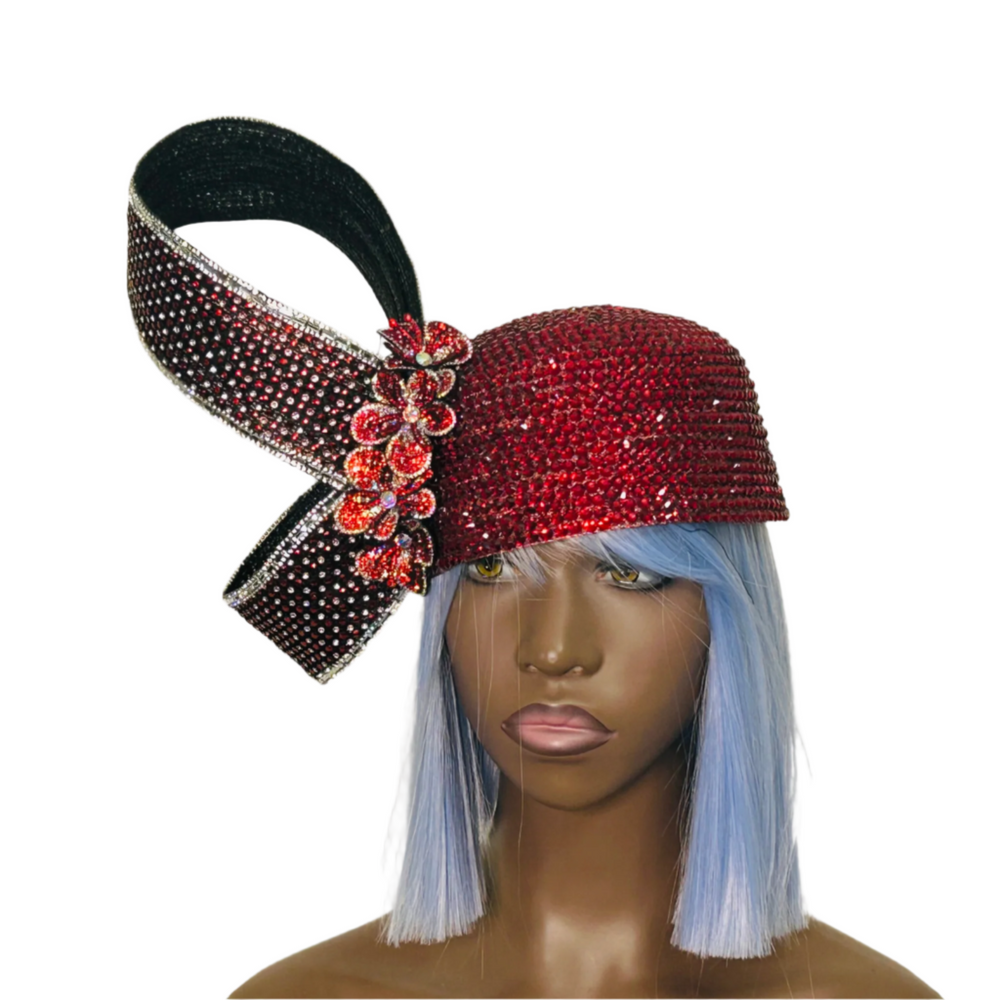 Mannequin head with a red and black embellished headpiece on a gray background
