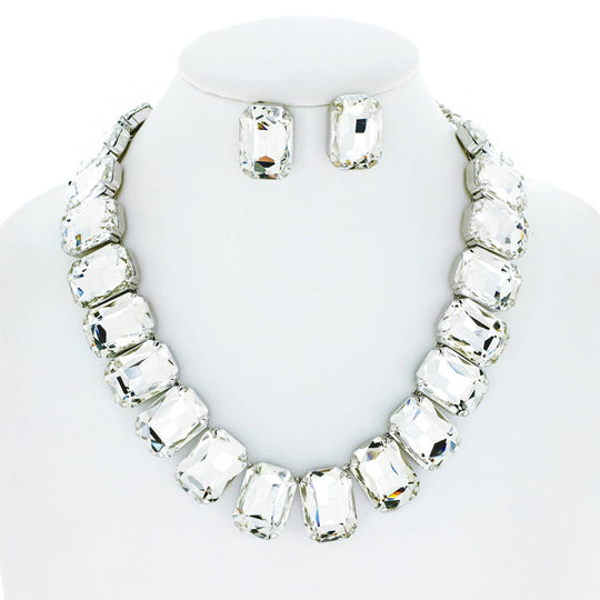 A crystal octagon cut collar necklace set displayed on a mannequin, consisting of a necklace and a pair of earrings with a silver-tone and clear crystal design.