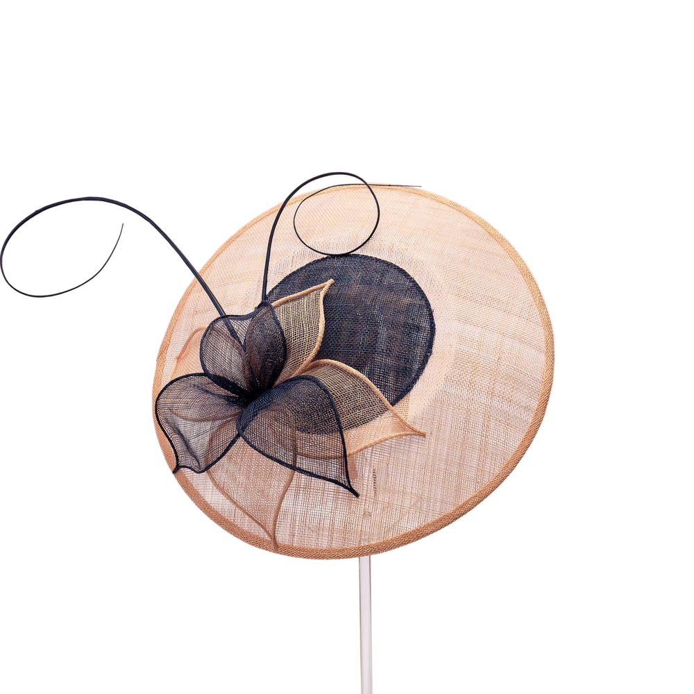 Decorative hat with black bow and beige base on a white background