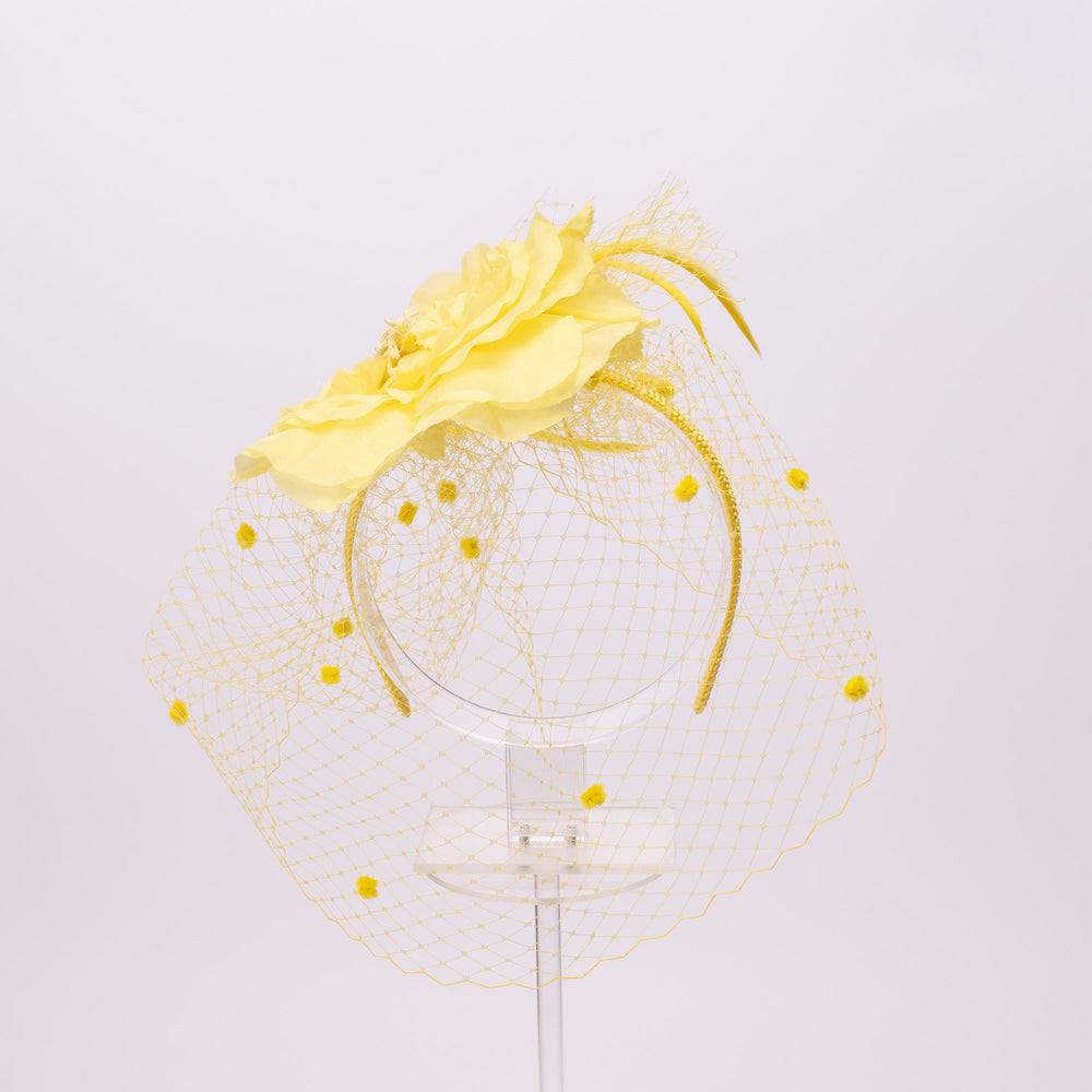 Yellow floral headpiece with a clear base on a light gray background