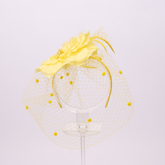 Yellow floral headpiece with a clear base on a light gray background
