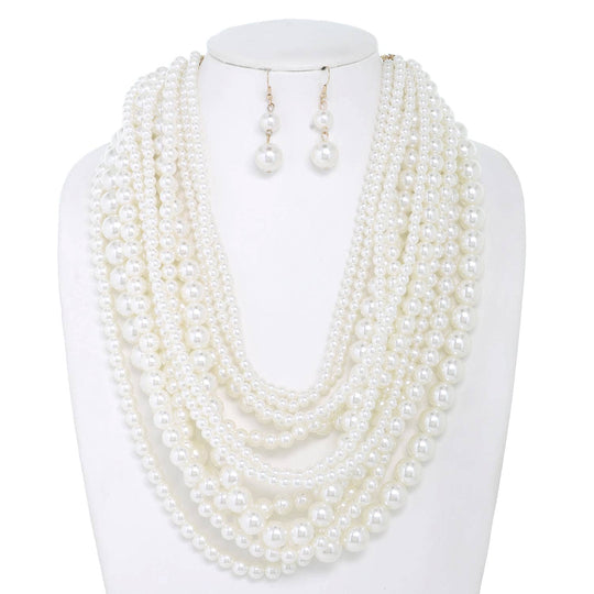 A mannequin showcasing a multi-strand draped pearl necklace with matching earrings.