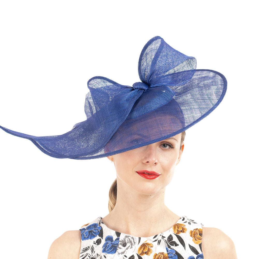 Woman wearing a large blue decorative hat on a white background