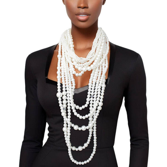 Woman wearing multi-strand cream pearl necklace with matching pearl earrings