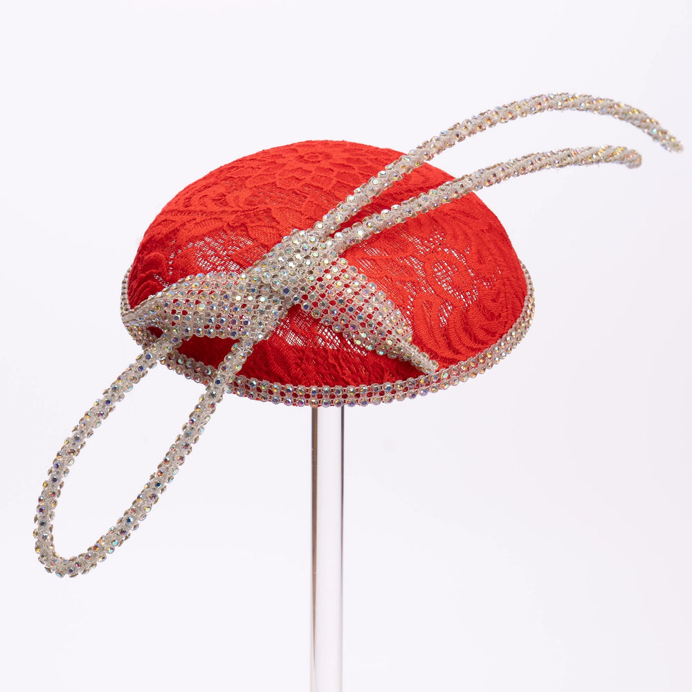 Red lace hat with a decorative bow on a white background