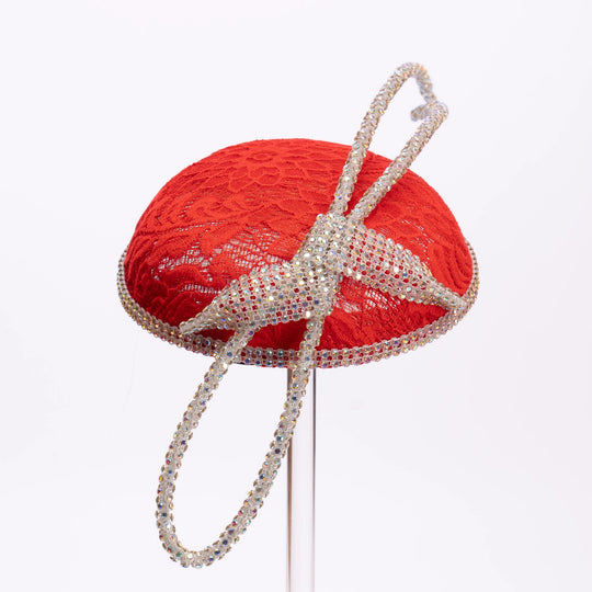 Red decorative hat with a decorative bow on a white background