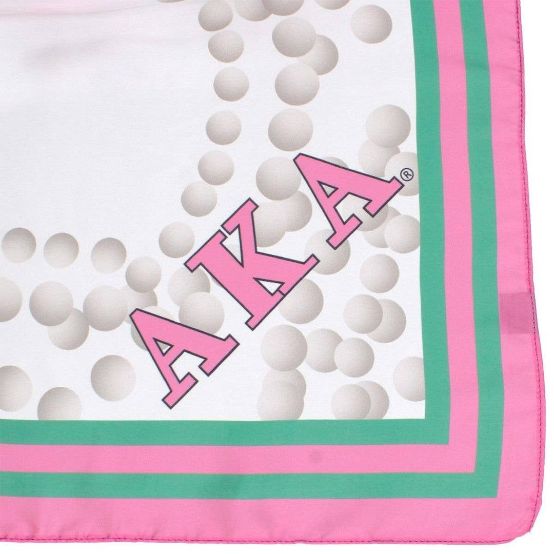 Fabric with 'AKA' letters and pink and green border on a white background