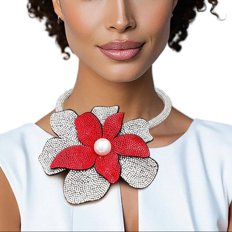 Woman wearing a white top with a red floral accessory on a white background