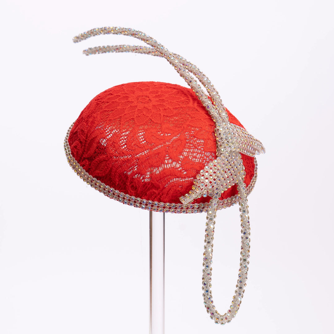 Red lace hat with decorative headband on a white background