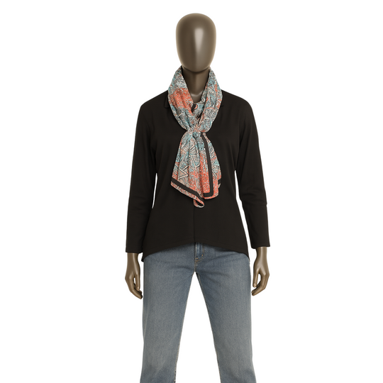 Mannequin wearing a black top, patterned scarf, and jeans on a white background