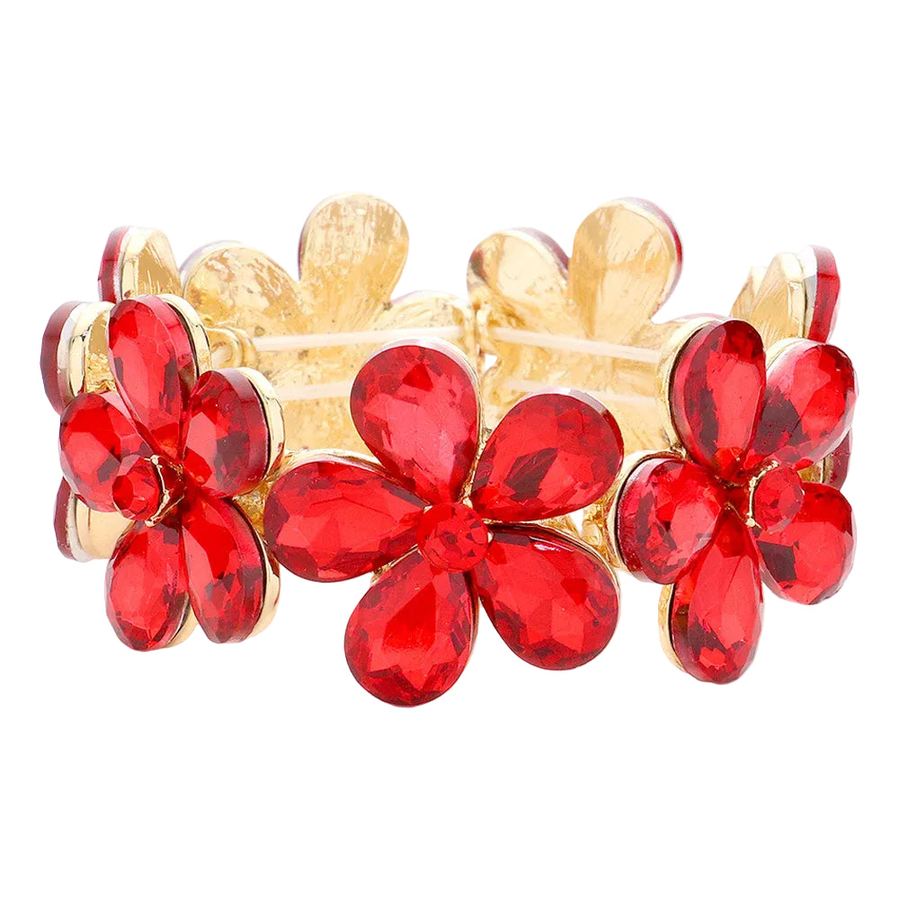 Gold bracelet with red flower-shaped stones on a white background