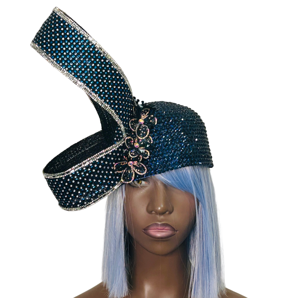 Decorative black hat with blue embellishments on a mannequin head against a gray background