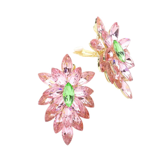Pink floral earrings with green gemstones on a light gray background