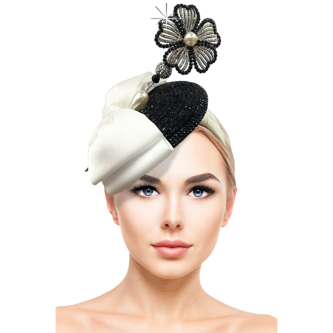 Woman wearing a decorative headpiece with a black and white design on a white background