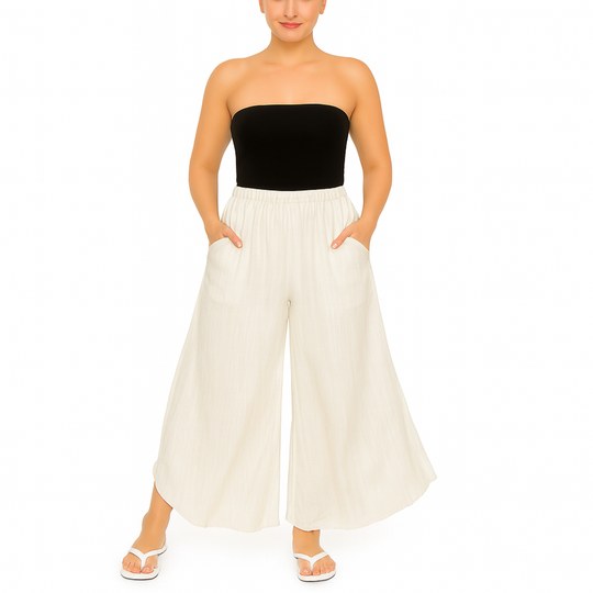 Woman wearing a black strapless top and white wide-leg pants on a white background