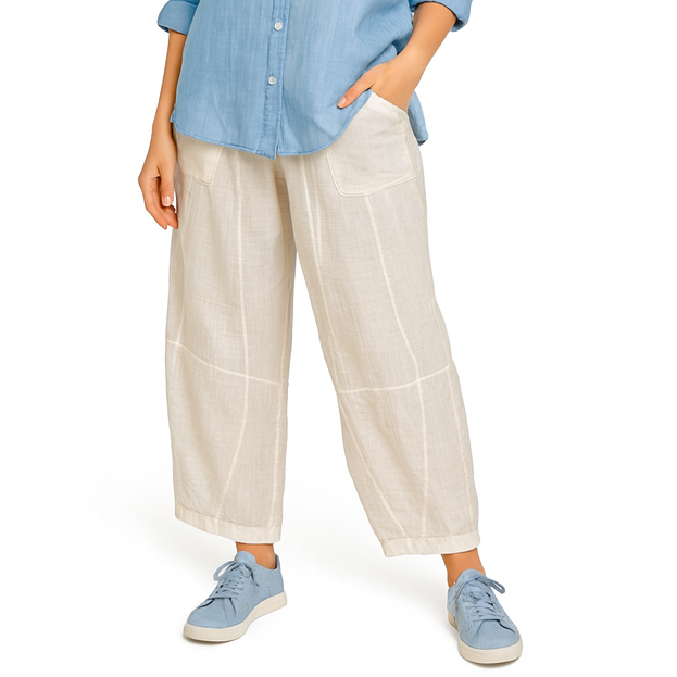 Woman wearing a blue shirt and white pants on a white background