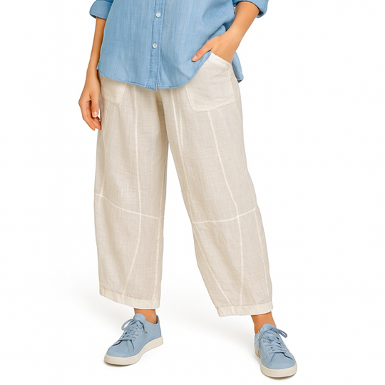 Woman wearing a blue shirt and white pants on a white background