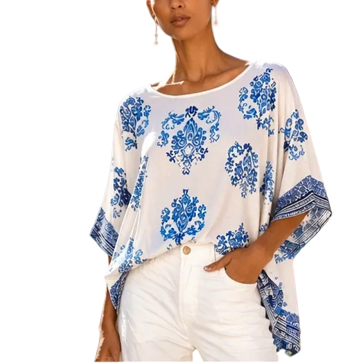 Woman wearing a white blouse with blue floral patterns in a scenic location.