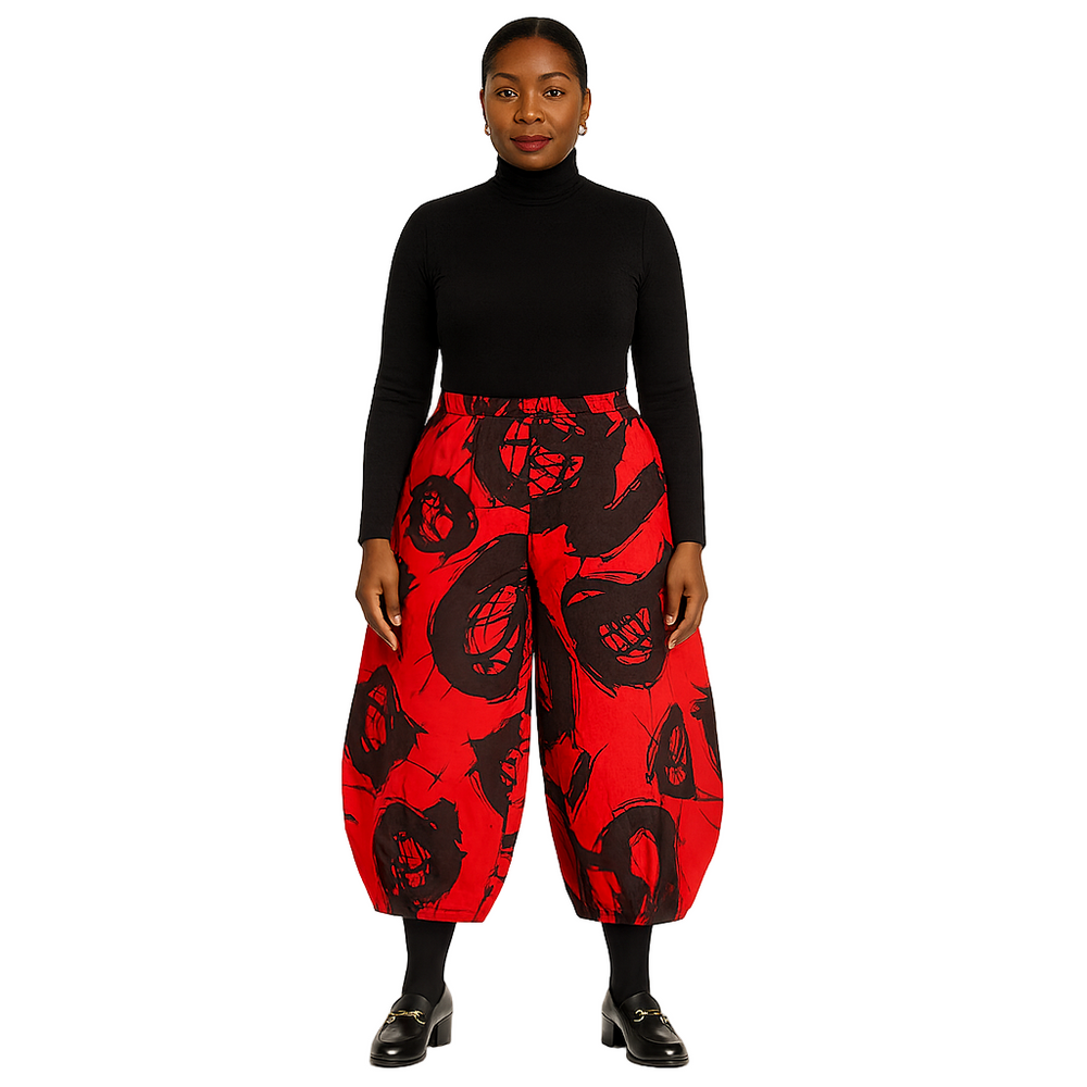 Person wearing a black turtleneck and red patterned pants on a white background