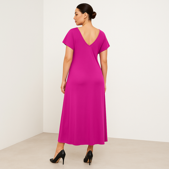 Woman wearing a bright pink dress with a plain background