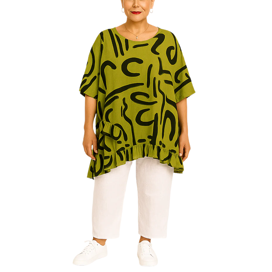 Woman wearing a green patterned top and white pants on a white background